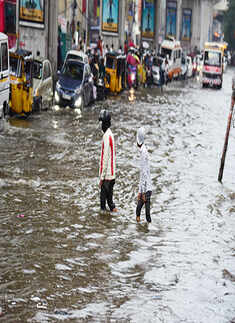 People wade through a flooded road