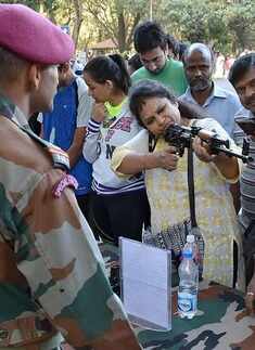 A woman takes aim with a rifle