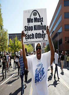A woman holds a sign outside the St. Louis Metropolitan Police Department