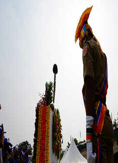 A police personnel pays homage to martyrs